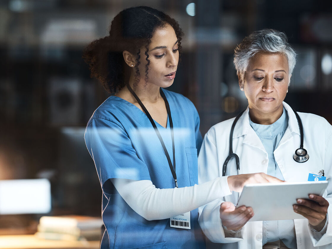 A doctor and nurse reviewing patient information on a tablet